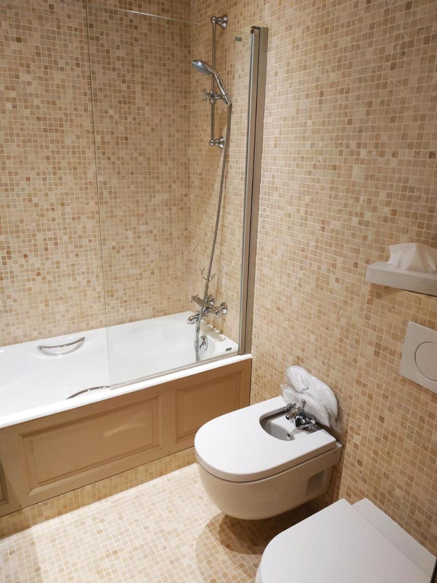 une salle de bain avec une baignoire, des toilettes et un lavabo dans l'établissement Hotel d'Europe, à Avignon