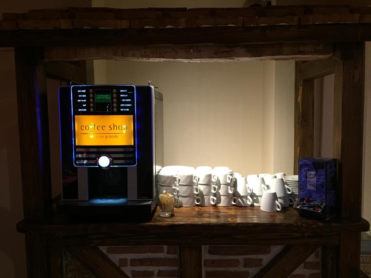 un four micro-ondes assis au-dessus d'une table avec des tasses dans l'établissement Le Pavillon, à Cours-la-Ville