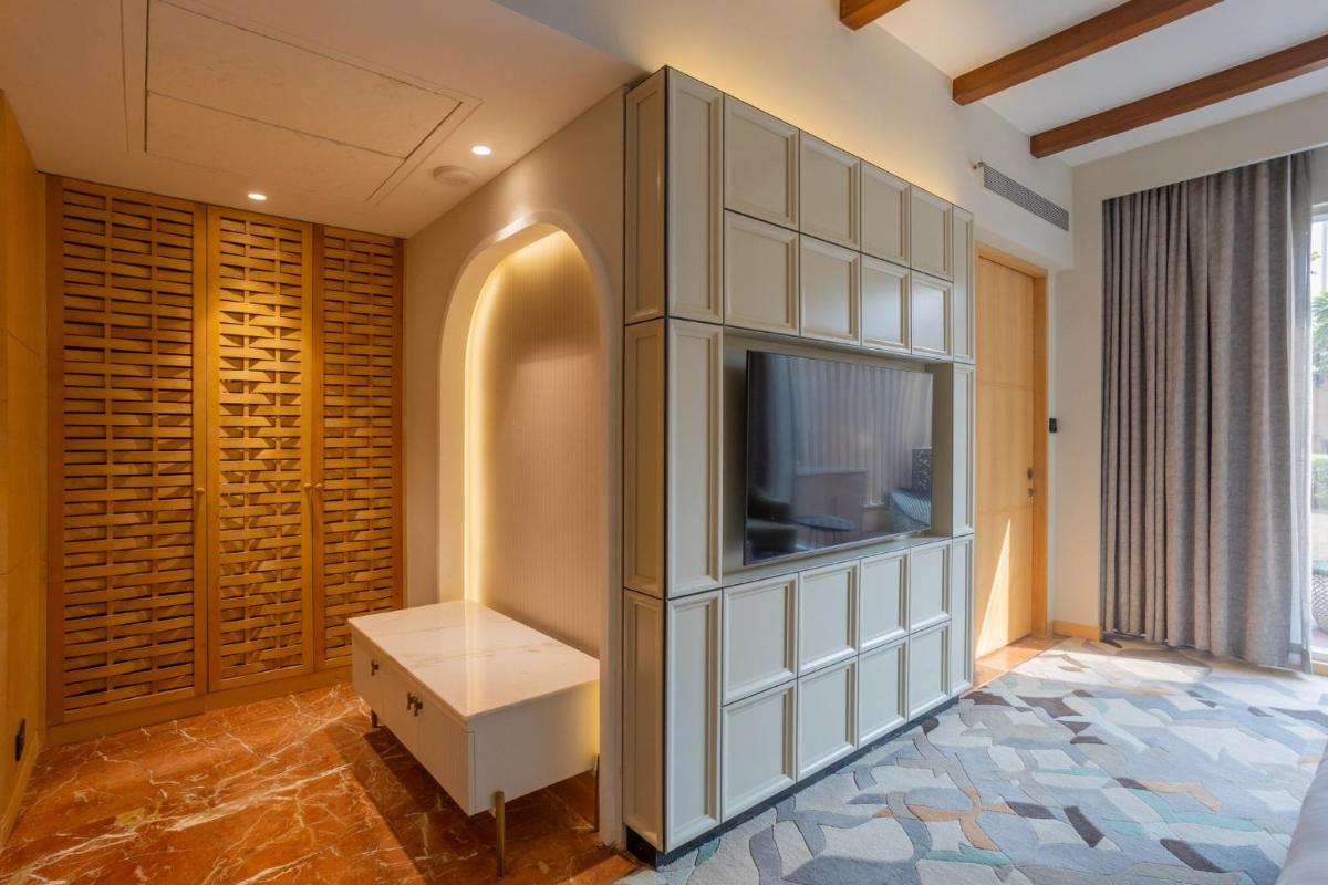 a living room with a tv and a entertainment center at InterContinental Jaipur Tonk Road by IHG in Jaipur