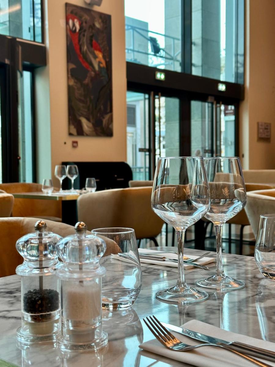 une table dans un restaurant avec des verres à vin dessus dans l'établissement Hotel Spa Le Pasino, au Havre