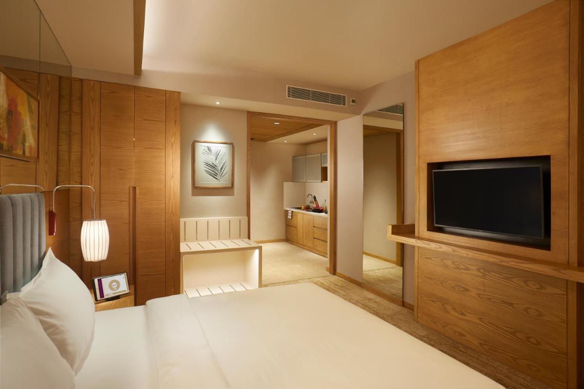 a bedroom with a bed and a television in a room at The Residency Towers in Chennai