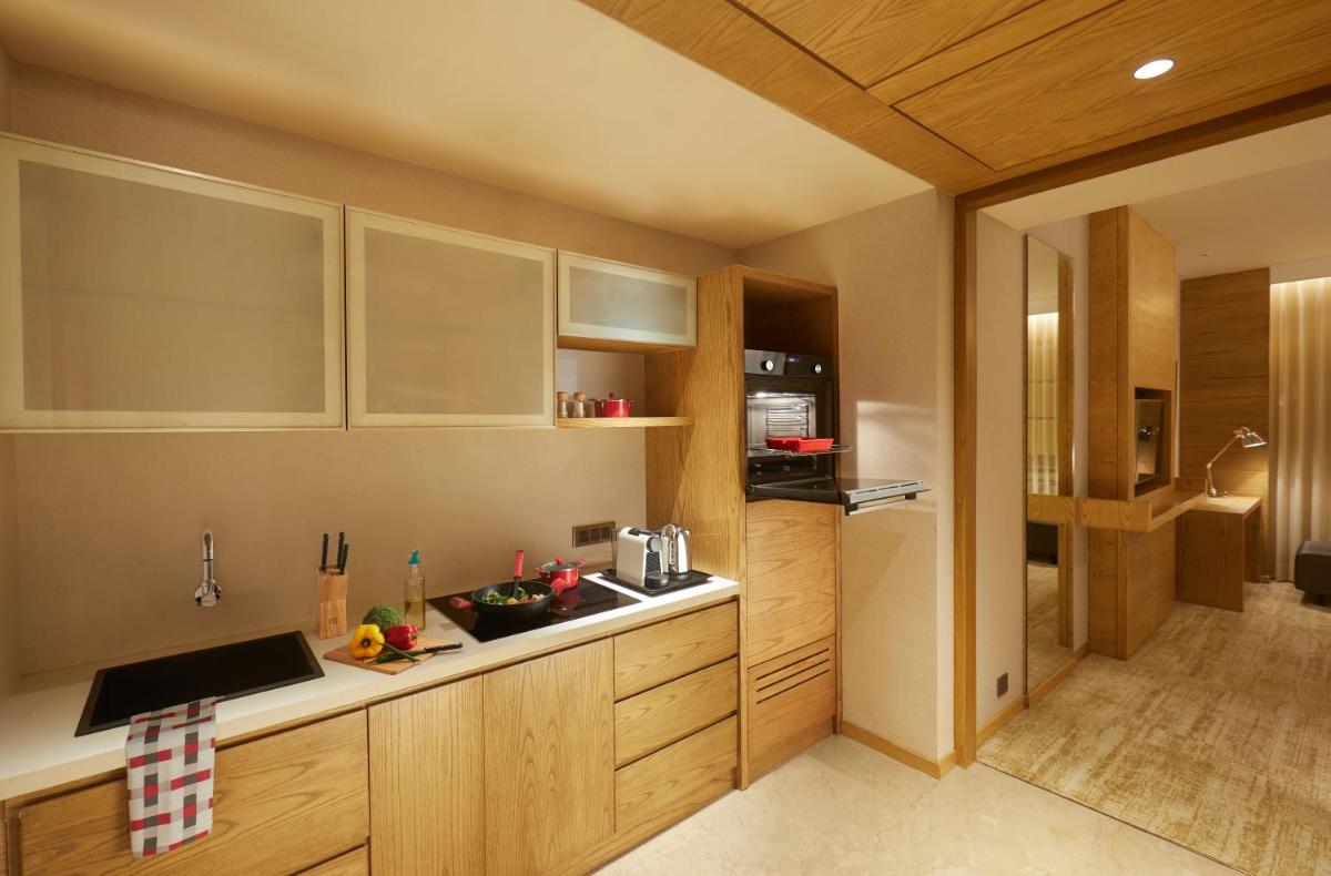 a kitchen with wooden cabinets and a counter top at The Residency Towers in Chennai