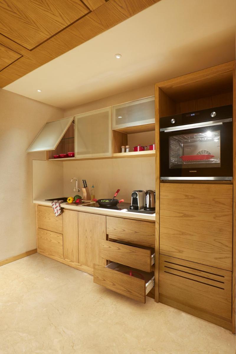 a kitchen with wooden cabinets and a counter top at The Residency Towers in Chennai