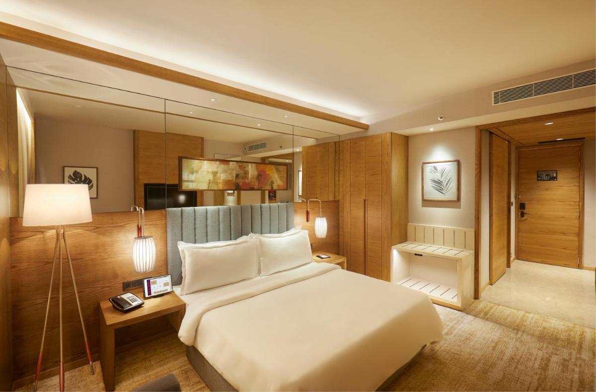 a bedroom with a large white bed and a desk at The Residency Towers in Chennai