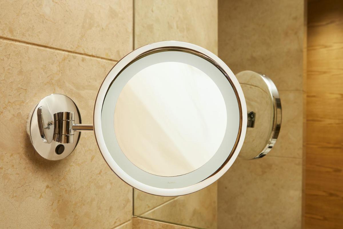 a mirror on the wall of a bathroom at The Residency Towers in Chennai