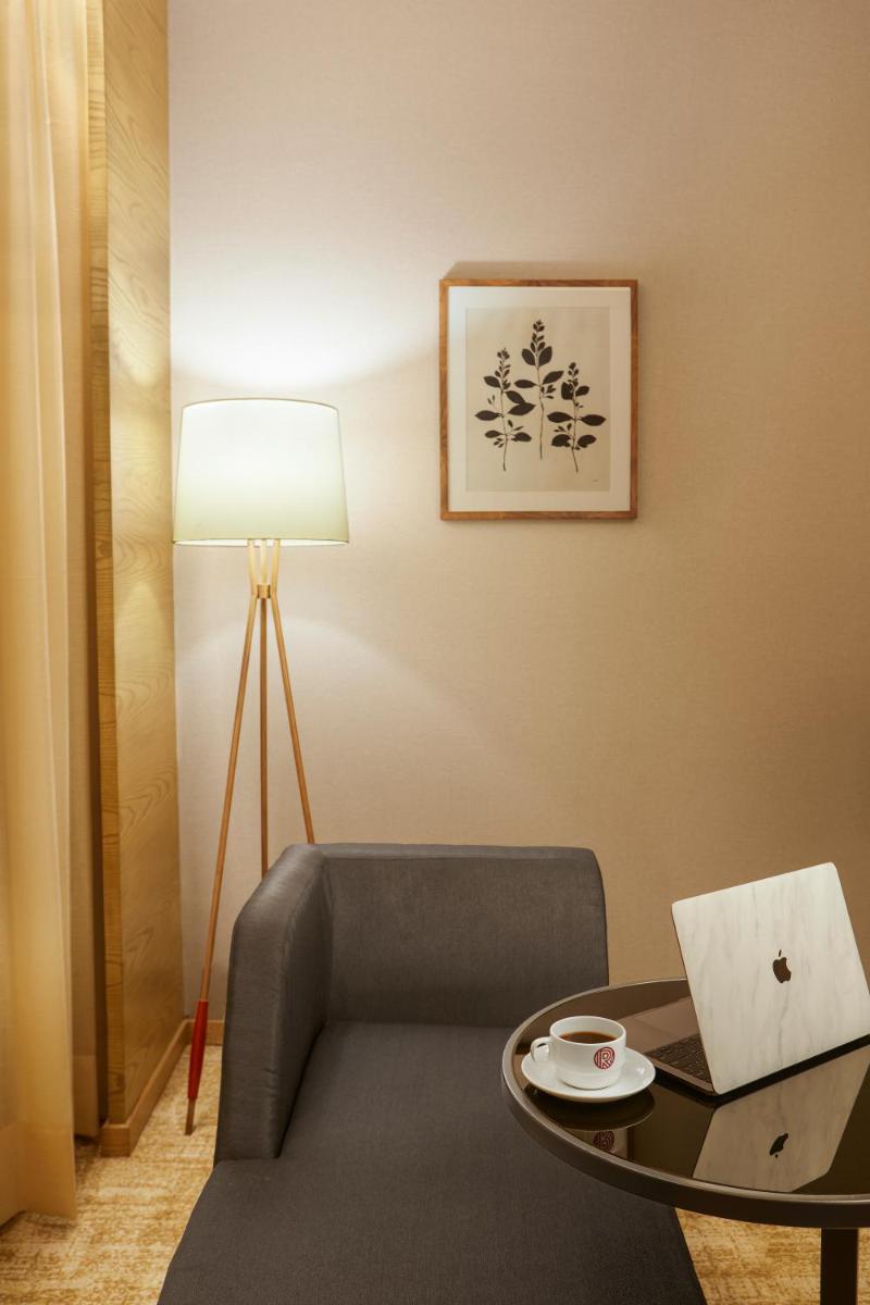 a room with a chair and a table with a laptop at The Residency Towers in Chennai