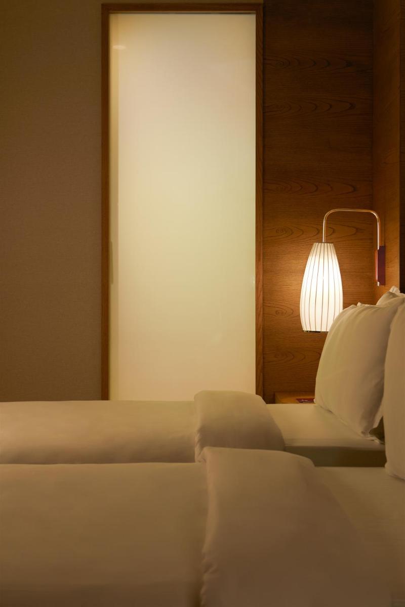 a bedroom with a bed with a lamp and a mirror at The Residency Towers in Chennai