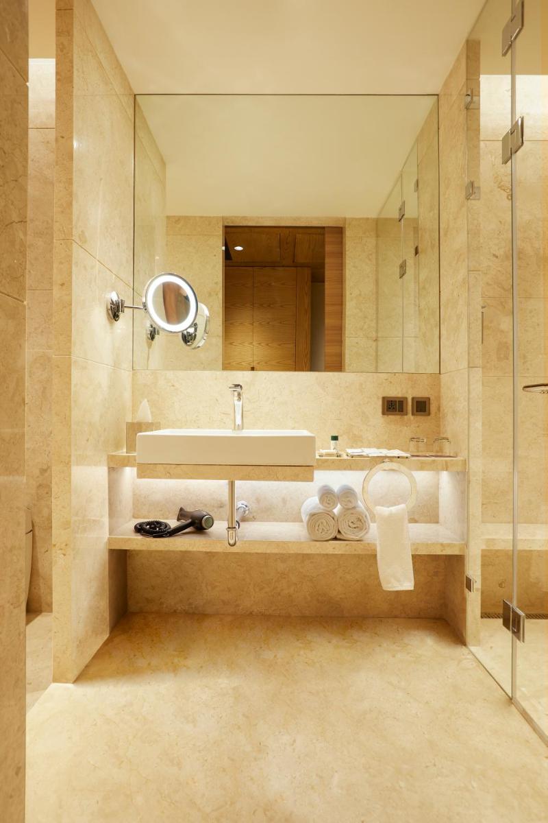 a bathroom with a sink and a mirror at The Residency Towers in Chennai