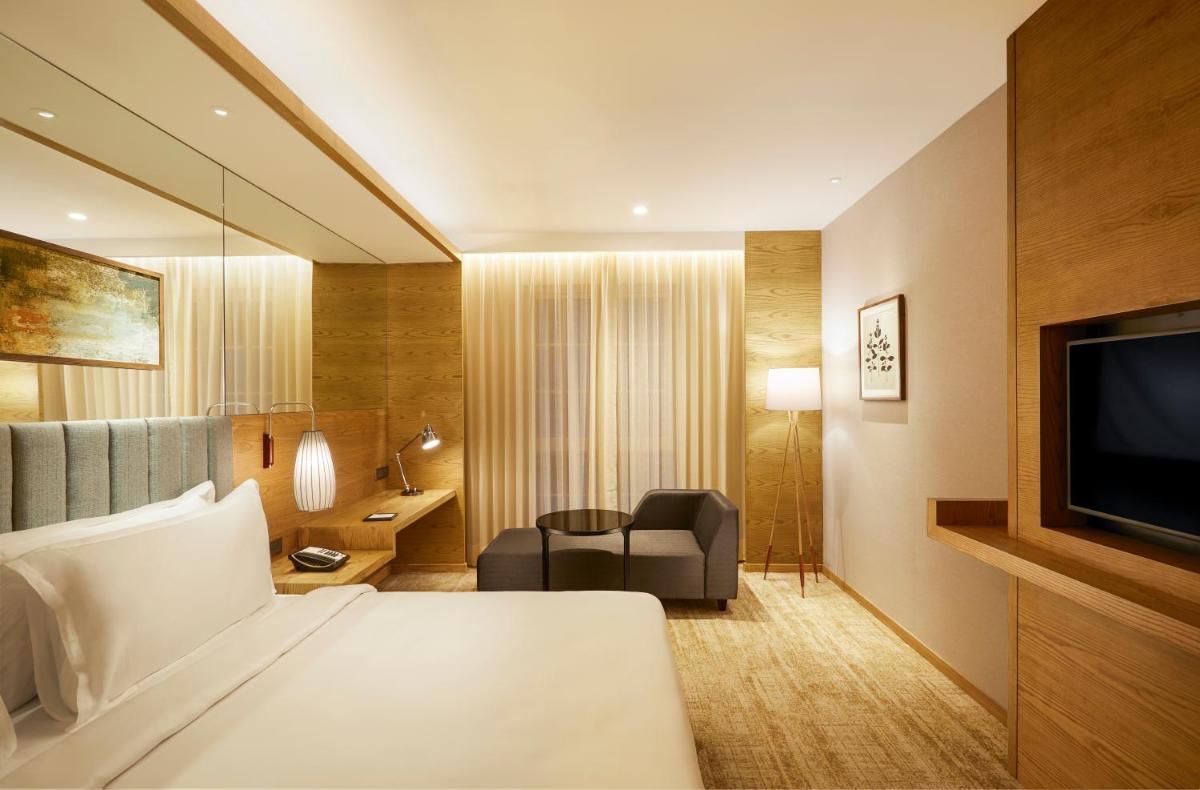 a hotel room with a bed and a television at The Residency Towers in Chennai