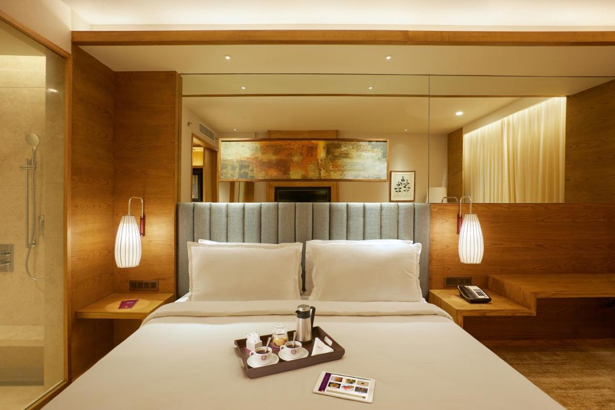 a bedroom with a bed with a tray of candles on it at The Residency Towers in Chennai