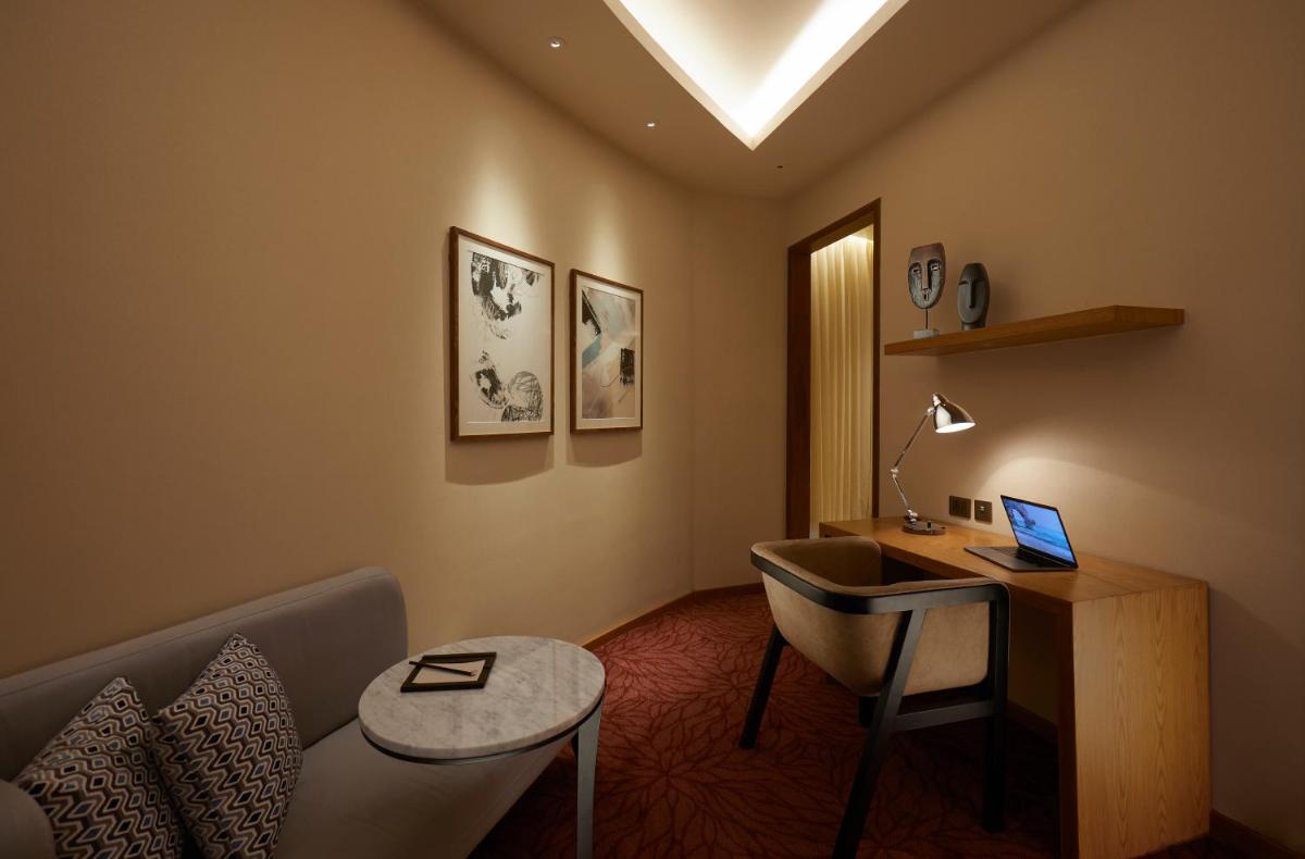 a room with a desk and a laptop on a table at The Residency Towers in Chennai