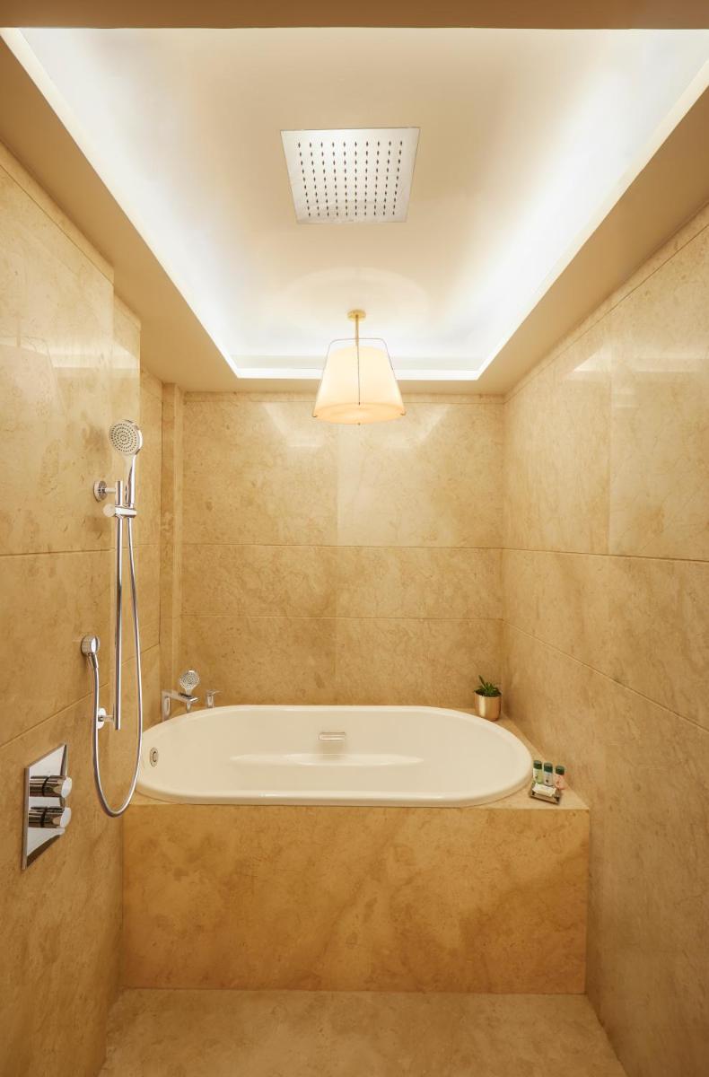 a bathroom with a bath tub in a room at The Residency Towers in Chennai