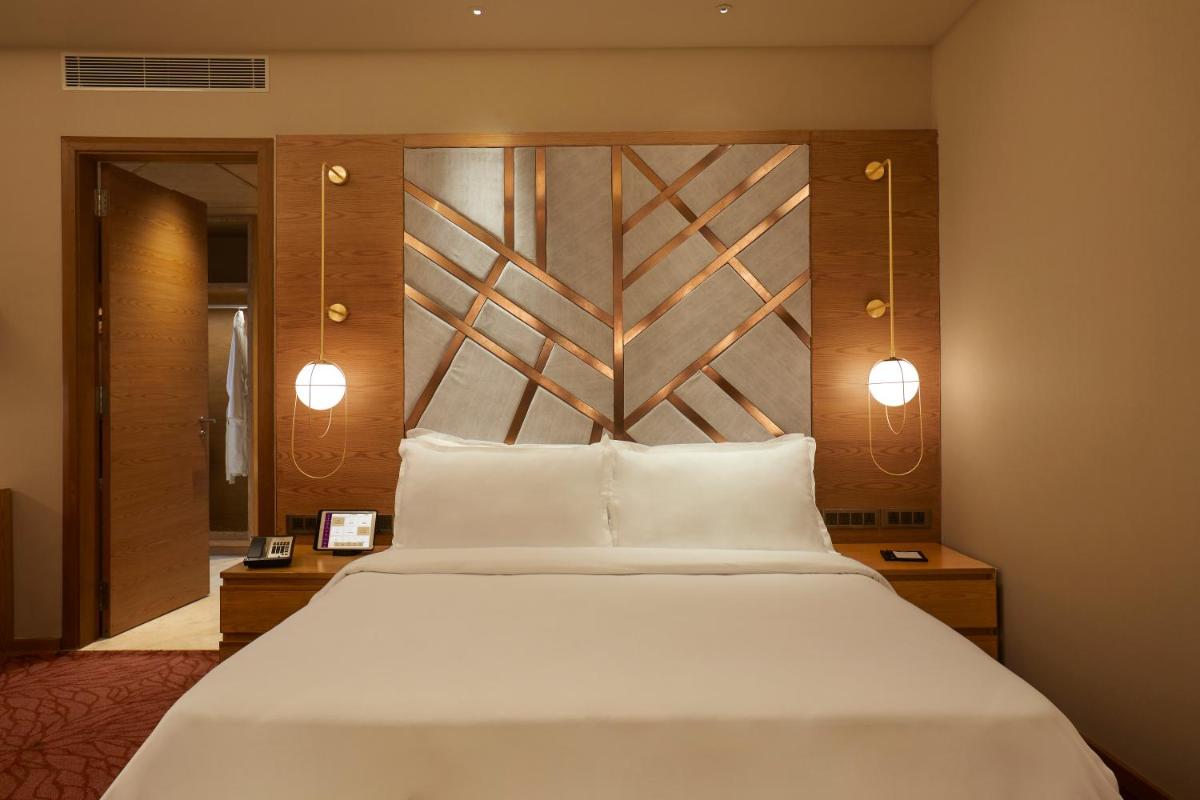 a bedroom with a large white bed and two lights at The Residency Towers in Chennai