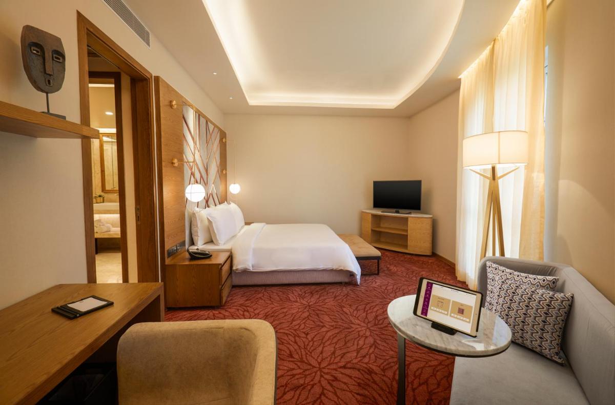 a hotel room with a bed and a couch at The Residency Towers in Chennai