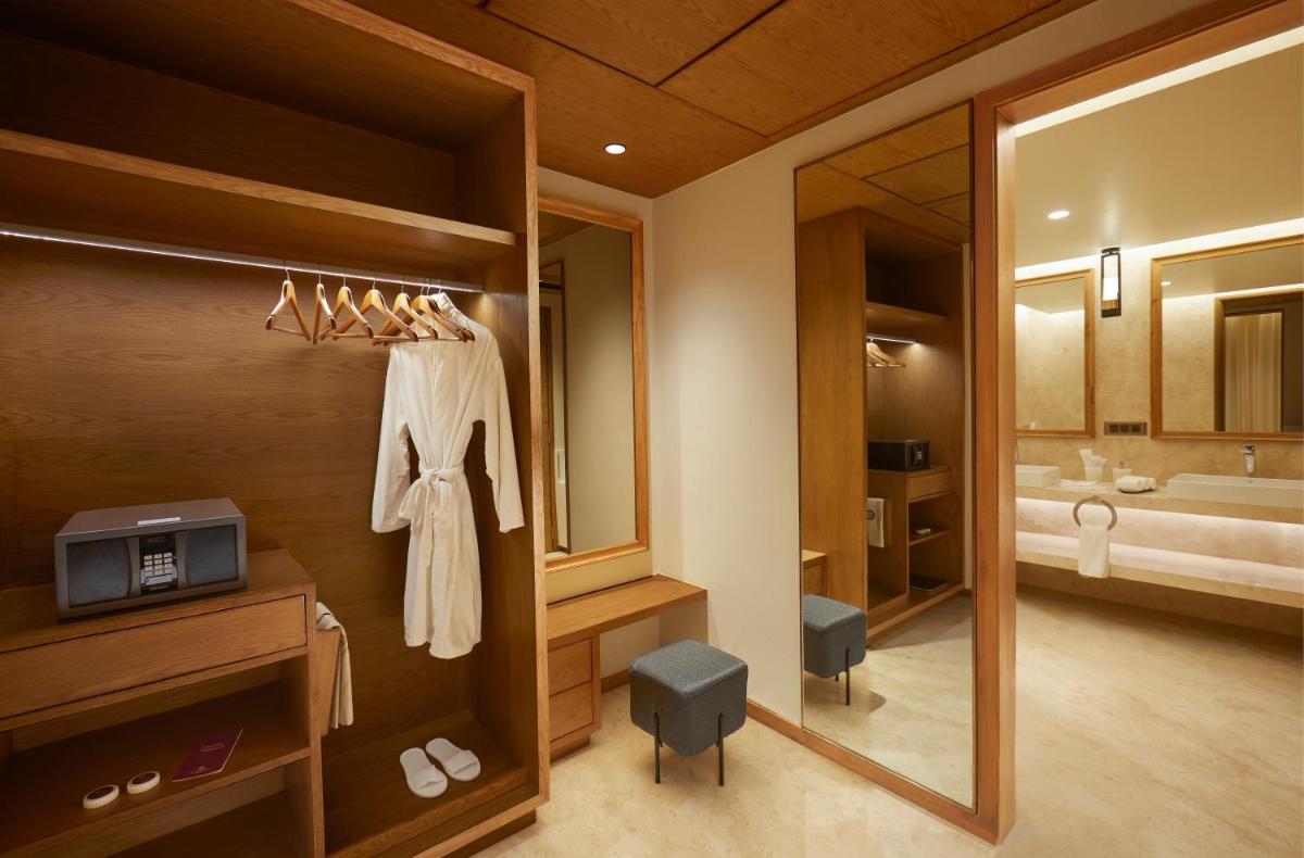 a bathroom with a large mirror and a bathroom with a sink at The Residency Towers in Chennai