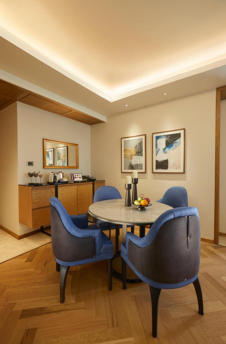 a dining room with blue chairs and a table at The Residency Towers in Chennai