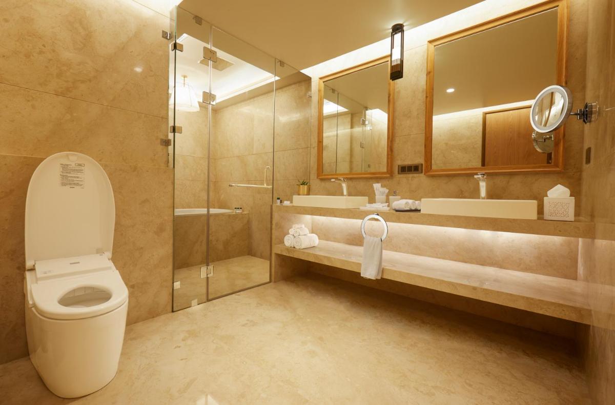 a bathroom with a toilet and a shower and a sink at The Residency Towers in Chennai