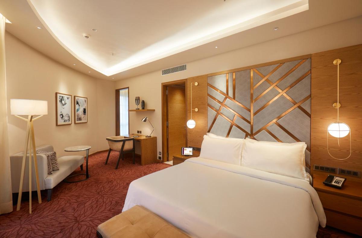 a hotel room with a bed and a desk at The Residency Towers in Chennai