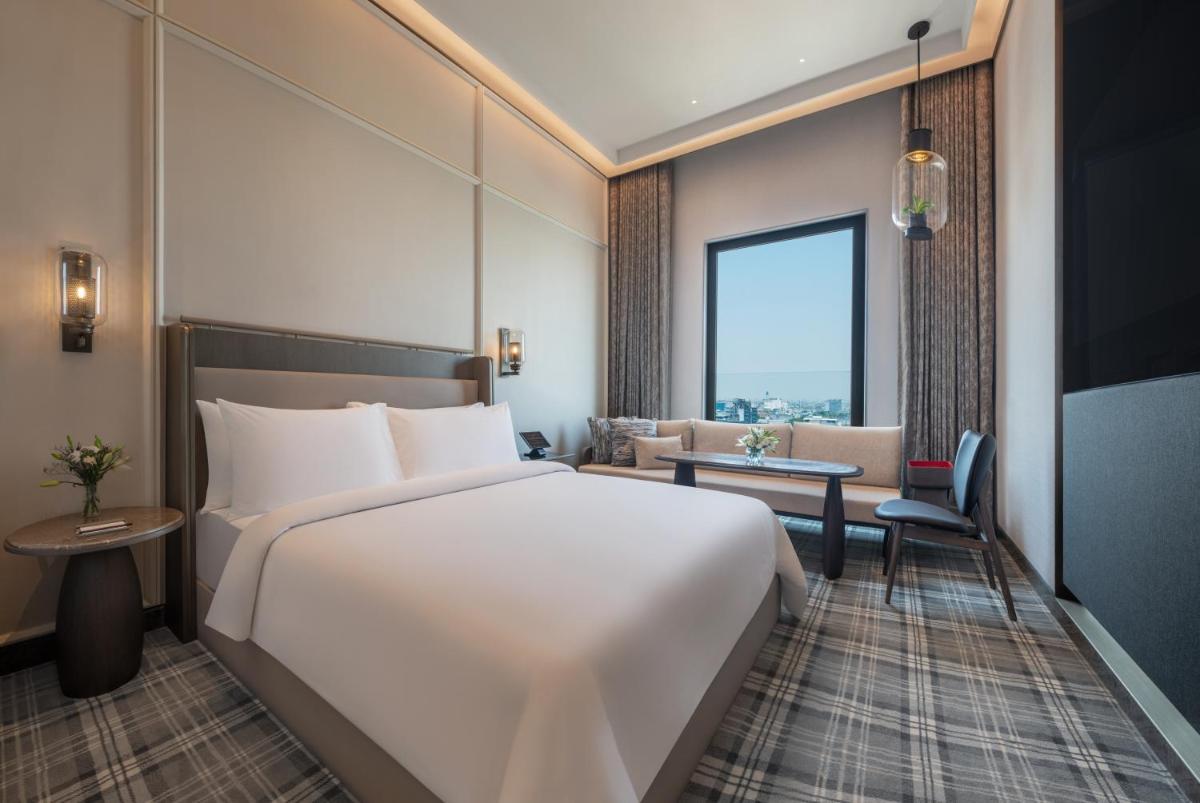 a hotel room with a large bed and a desk at The Residency Towers in Chennai
