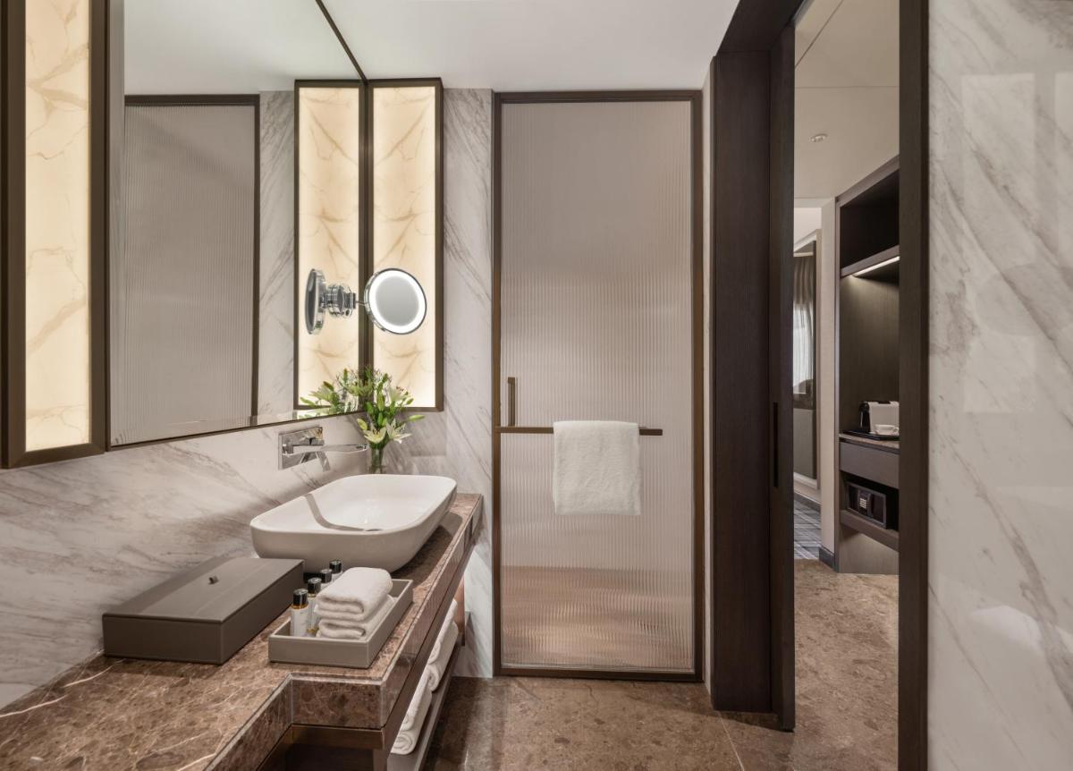 a bathroom with a sink and a mirror at The Residency Towers in Chennai +53 photos