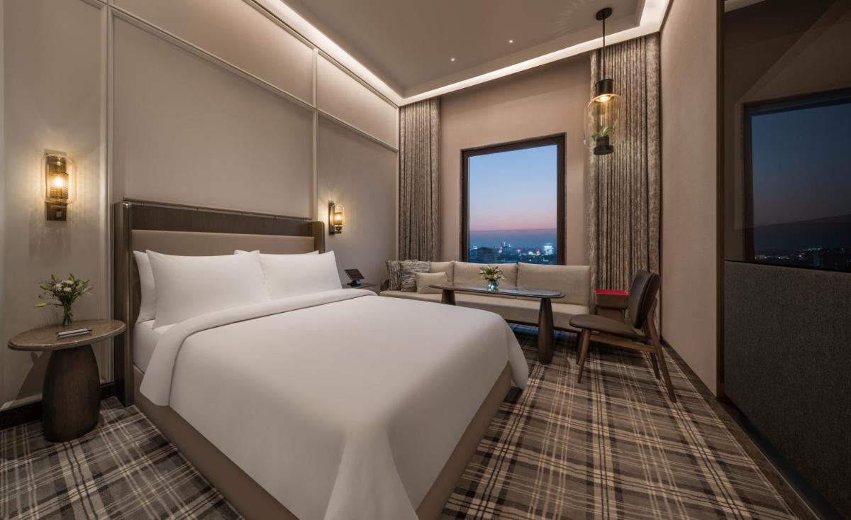 a bedroom with a large white bed and a desk at The Residency Towers in Chennai