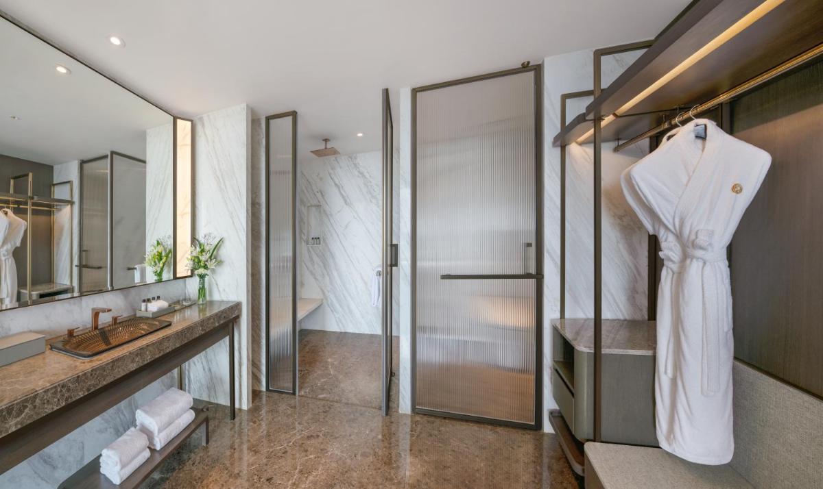 a bathroom with a white robe hanging on a wall at The Residency Towers in Chennai