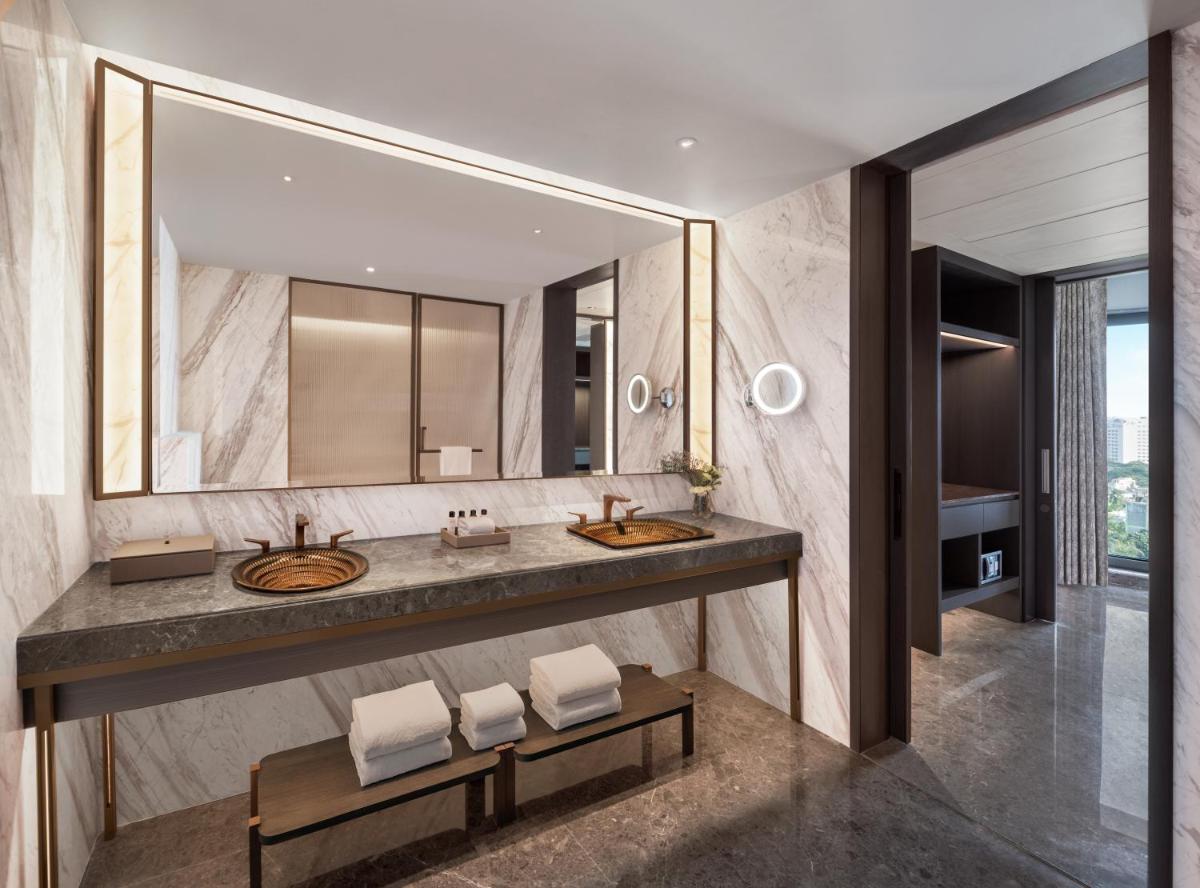 a bathroom with two sinks and a large mirror at The Residency Towers in Chennai