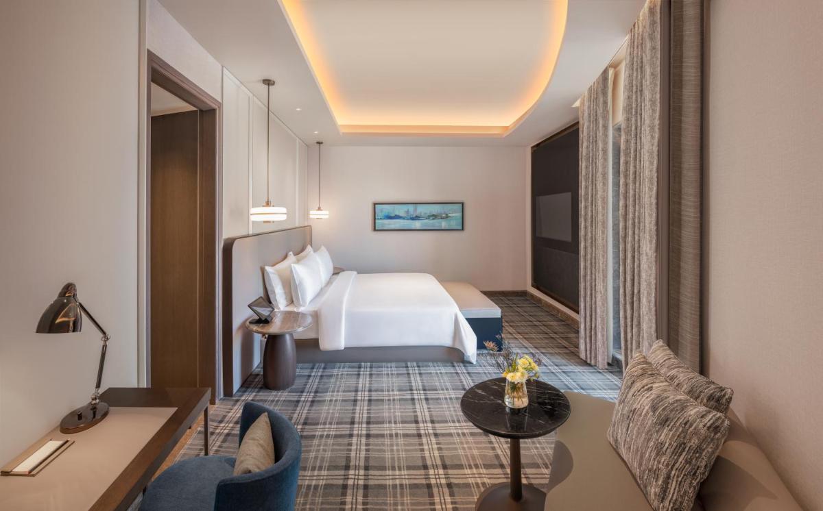 a hotel room with a bed and a table at The Residency Towers in Chennai