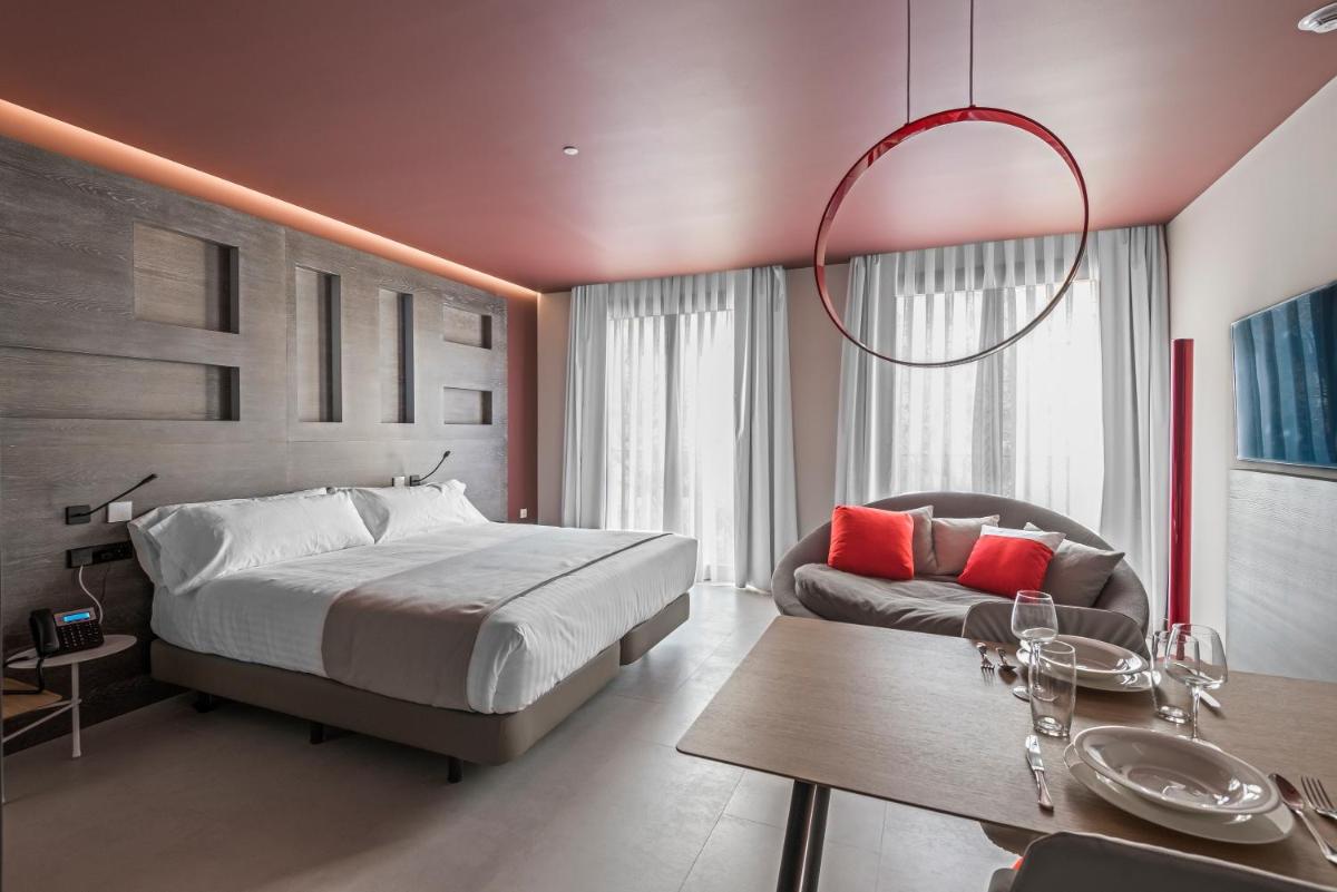 Un dormitorio con una cama, un sofá y una mesa. en MYR Plaza Mercado & Spa, en Valencia