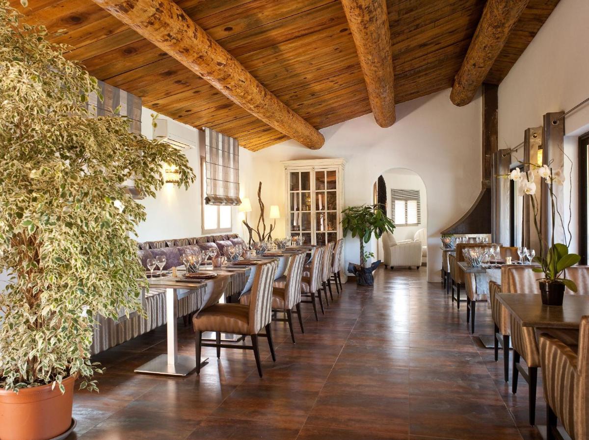 un restaurant avec des plafonds en bois, des tables et des chaises dans l'établissement Hôtel Ambassador Palombaggia, à Porto-Vecchio