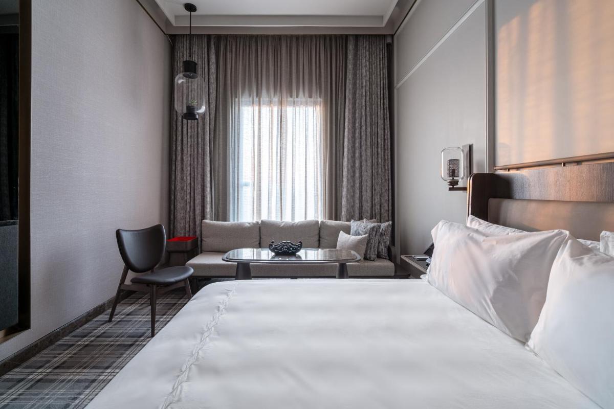 a hotel room with a bed and a couch at The Residency Towers in Chennai