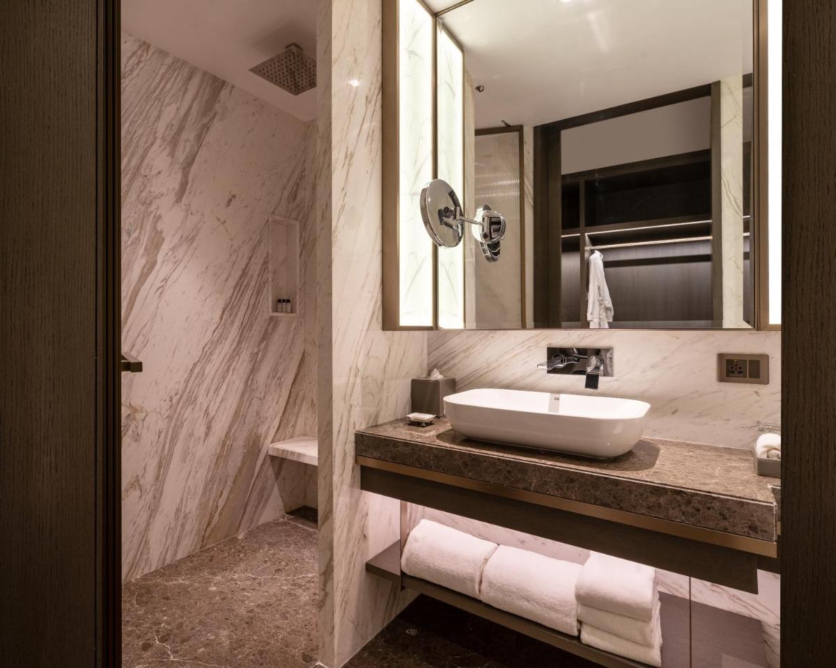 a bathroom with a sink and a mirror at The Residency Towers in Chennai