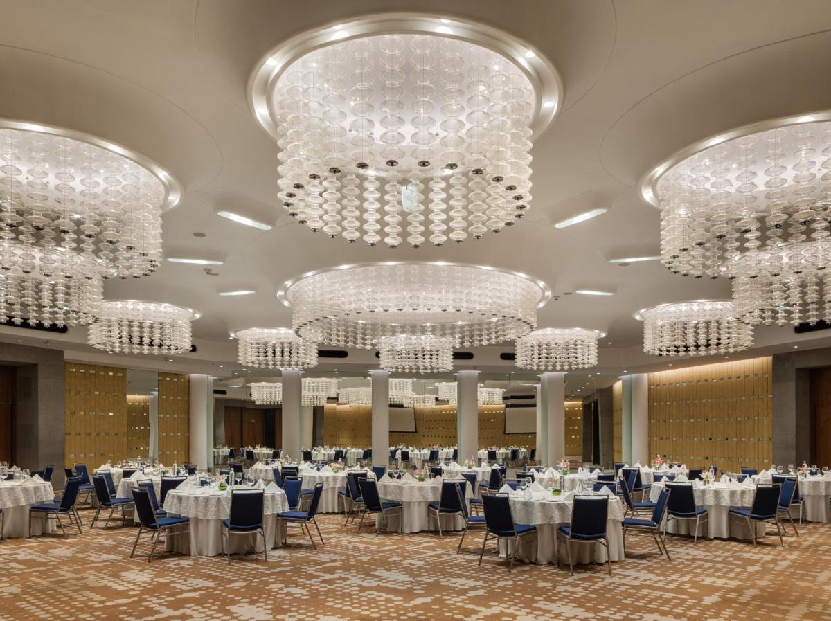 a banquet hall with white tables and chandeliers at Avasa Hotel in Hyderabad