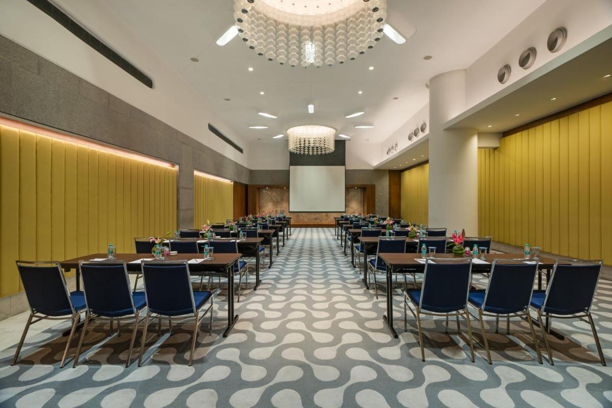 a banquet hall with tables and chairs and a podium at Avasa Hotel in Hyderabad