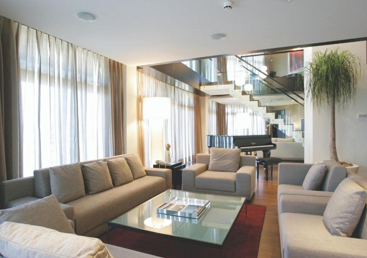 uma sala de estar com sofás e uma mesa de vidro em Montebelo Viseu Congress Hotel & Spa em Viseu