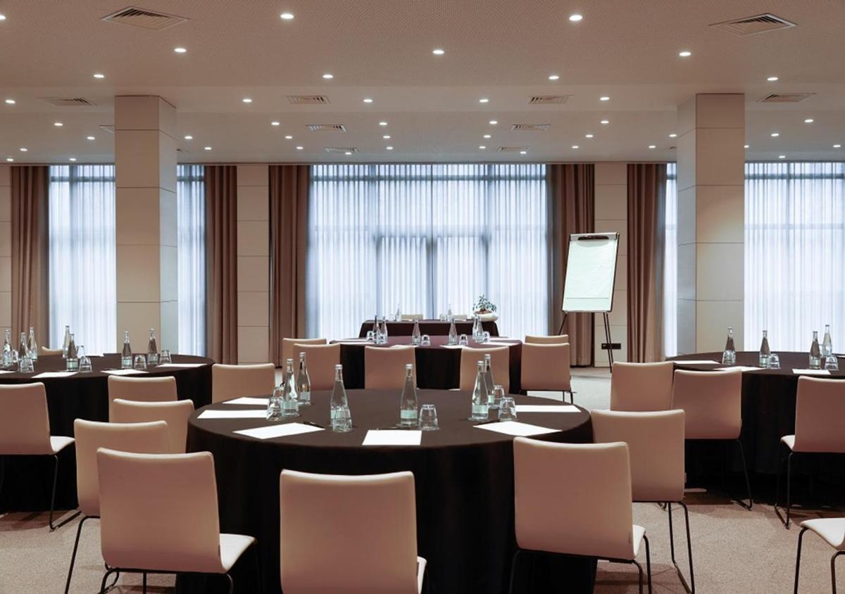 uma sala de conferências com mesas e cadeiras e um pódio em Montebelo Viseu Congress Hotel & Spa em Viseu
