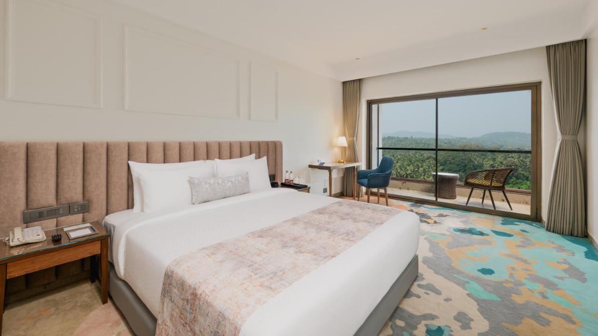 a hotel room with a bed and a large window at Gateway Goa, Palolem in Palolem