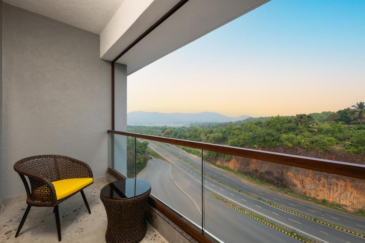 a balcony with a chair and a view of a highway at Gateway Goa, Palolem in Palolem