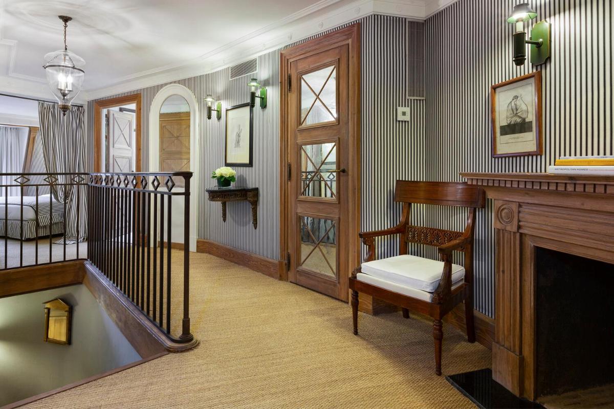 un salon avec un escalier et une cheminée dans l'établissement Le Dokhan's Paris Arc de Triomphe, a Tribute Portfolio Hotel, à Paris