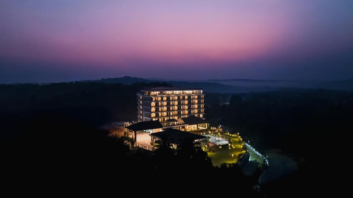 a tall building at night with a purple sky at Gateway Goa, Palolem in Palolem