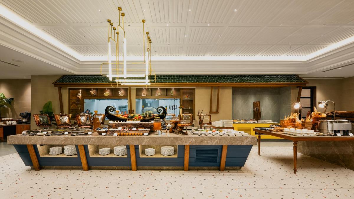 a kitchen with a large counter with food on it at Gateway Goa, Palolem in Palolem