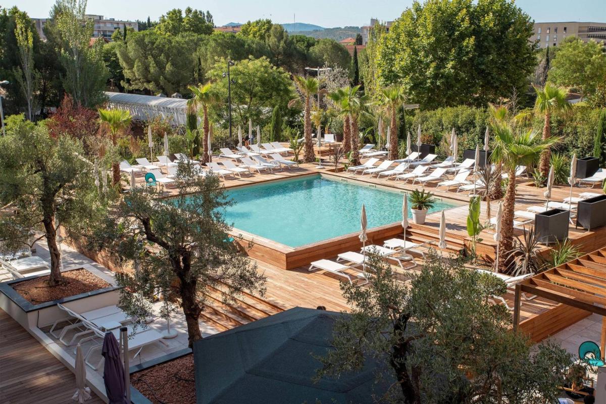 Vue aérienne d'une piscine avec chaises longues et arbres dans l'établissement Renaissance Aix-en-Provence Hotel, à Aix-en-Provence