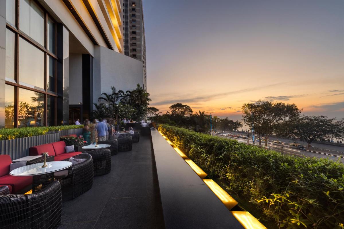a sidewalk with tables and chairs on a building at The Oberoi Mumbai in Mumbai
