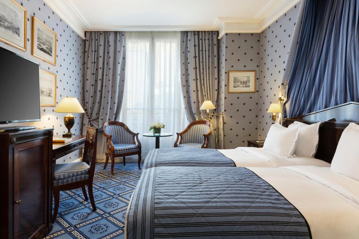 une chambre d'hôtel avec un lit et une télévision dans l'établissement Le Dokhan's Paris Arc de Triomphe, a Tribute Portfolio Hotel, à Paris