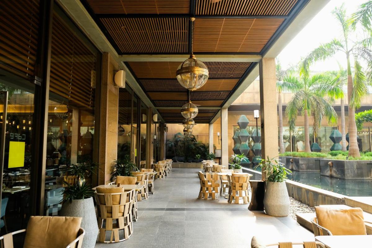 a restaurant with tables and chairs in a building at Crowne Plaza Today Gurugram by IHG in Gurgaon