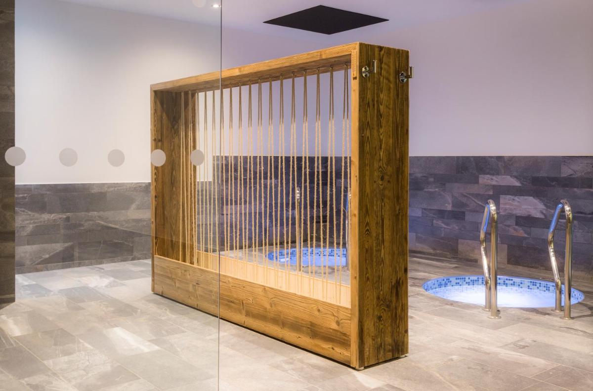 une cage en bois dans une chambre avec deux urinoirs dans l'établissement Hôtel Saint Charles Val Cenis, à Lanslebourg-Mont-Cenis