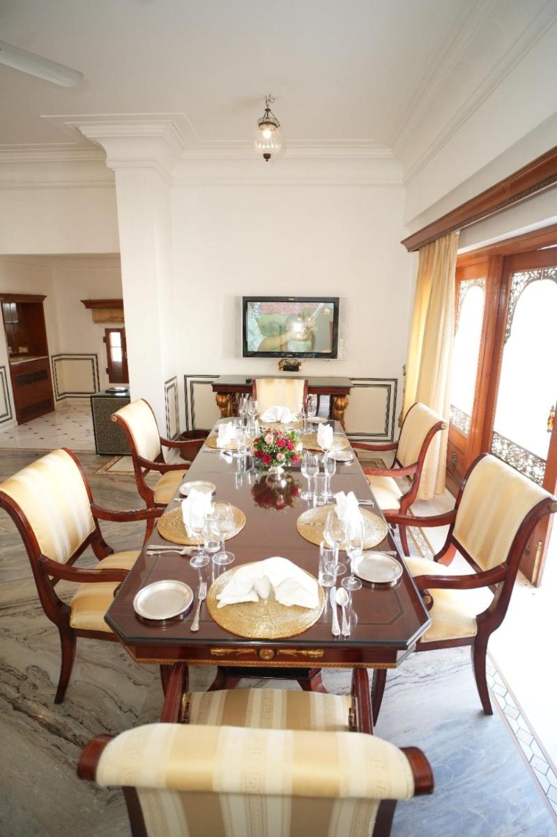 a dining room with a long table and chairs at The Raj Palace (Small Luxury Hotels of the World) in Jaipur