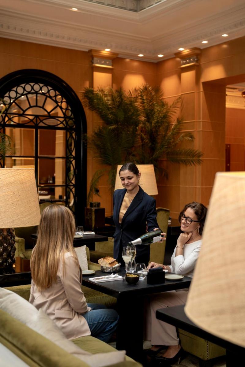 deux femmes assises à une table dans le hall d'un hôtel dans l'établissement Hyatt Paris Madeleine, à Paris