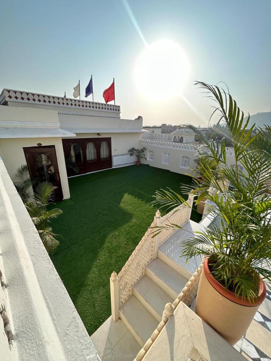 a house with a yard with a green lawn at The Raj Palace (Small Luxury Hotels of the World) in Jaipur