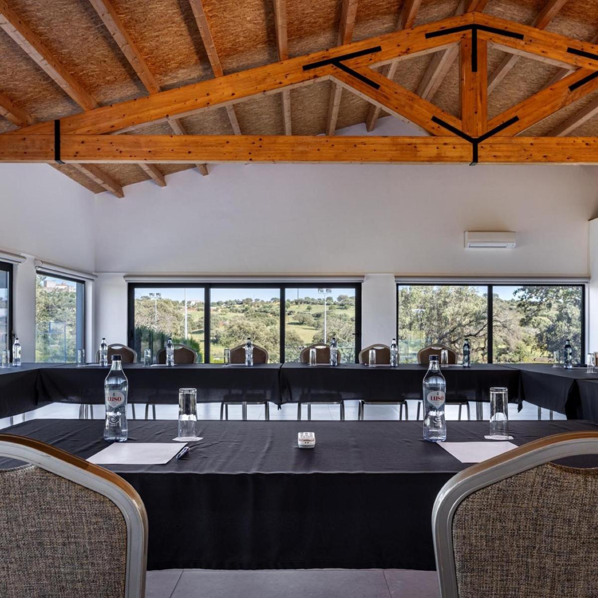 uma sala de conferências com uma mesa, cadeiras e janelas em Herdade dos Delgados em Mourão mais 39 fotografias